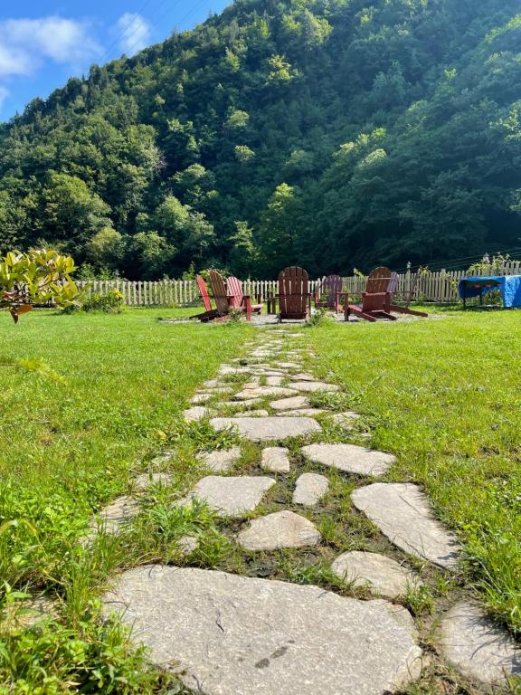 a stone path in a yard with chairs and a fence at DREAM RIVER EXCLUSIVE BUNGALOW in Çamlıhemşin