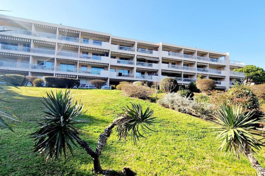 un edificio de apartamentos con palmeras delante en Studio Antibes avec piscine, en Antibes