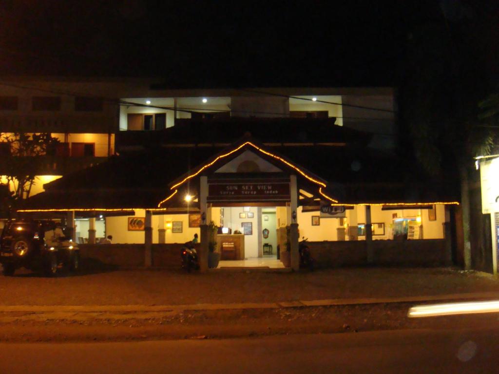 a gas station in front of a building at night at Sunset View Carita by Augusta hotel in Sukanegara