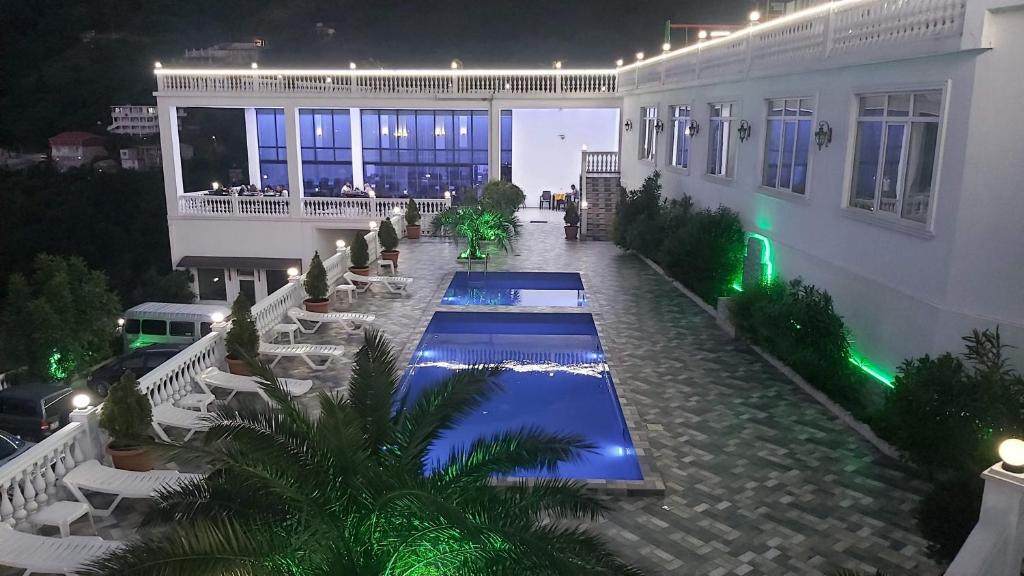 a swimming pool in a courtyard of a building at night at Zura palace in Kvariat'i