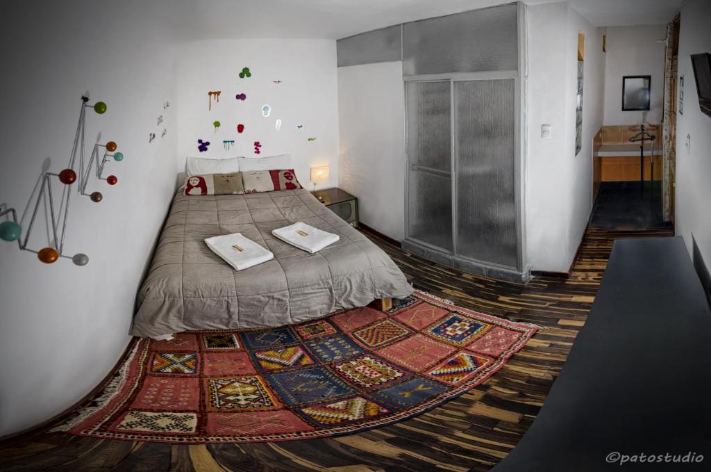 1 dormitorio con 1 cama con alfombra en el suelo en Hostal Bubamara, en Arequipa