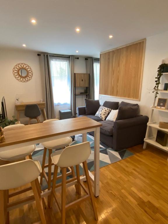 - un salon avec une table et un canapé dans l'établissement Cozy 2 pièces AUX PORTES DE PARIS !, à Issy-les-Moulineaux