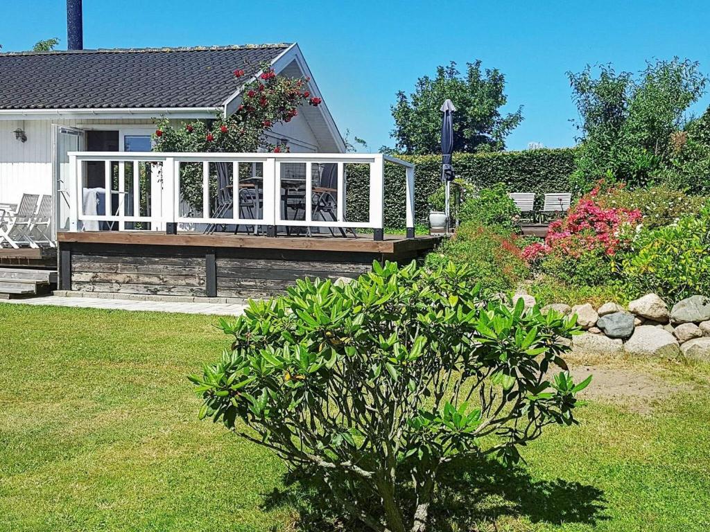 a house with a wooden deck with a porch at Two-Bedroom Holiday home in Stege 5 in Grevinge