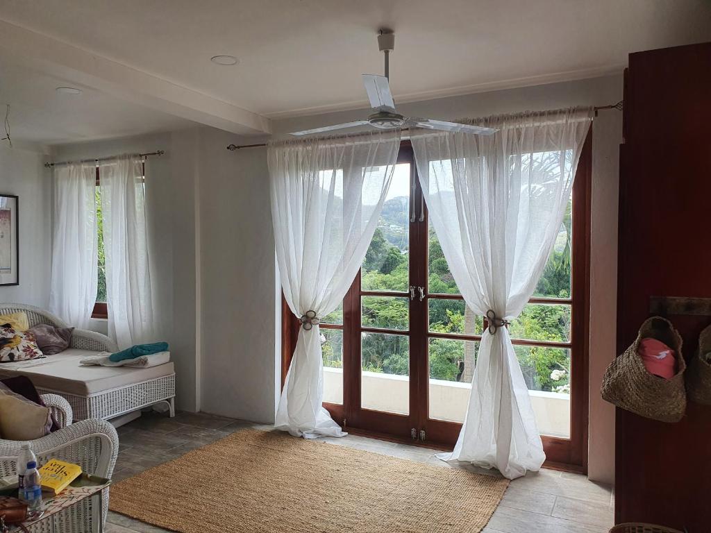 una sala de estar con una gran ventana con cortinas blancas en Harbour View House en Port Elizabeth
