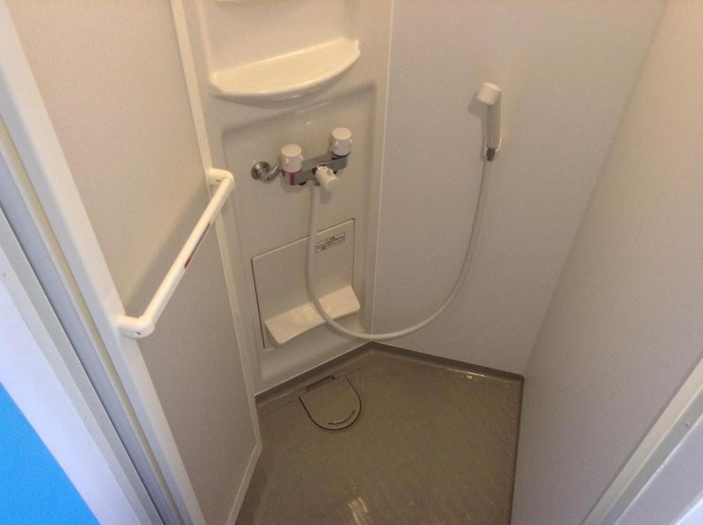 a small bathroom with a toilet in a room at Little Asia Guest House in Naha