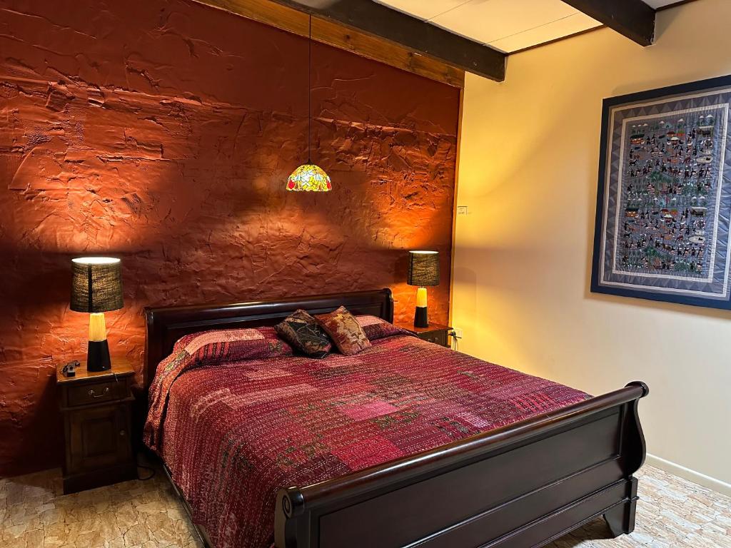 a bedroom with a bed and a red wall at Cedar Park Rainforest Resort in Kuranda