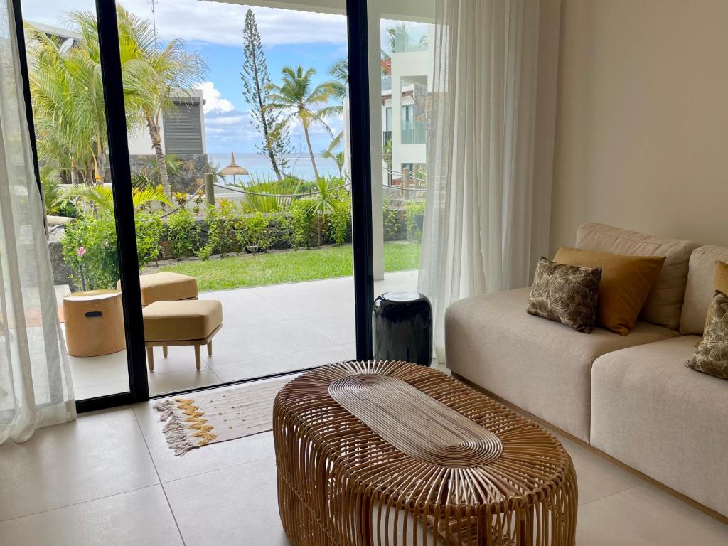 a living room with a couch and a ottoman at Exclusive beachfront apartment in Belle Mare