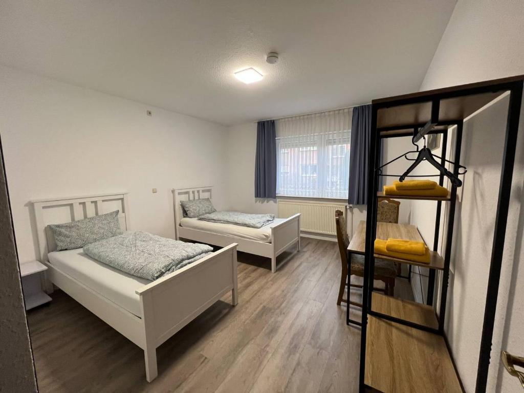 ein kleines Zimmer mit 2 Betten und einem Fenster in der Unterkunft Dill Apartments Peine in Peine