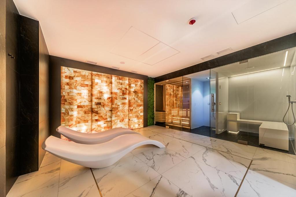 baño con banco blanco y pared de piedra en Aurum Aparthotel - Nowe Apartamenty blisko Plaży - Neue Appartements in Strandnähe, en Świnoujście