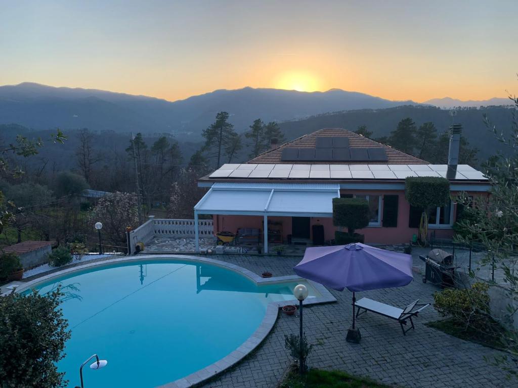 a house with a swimming pool in front of a sunset at La casa nel verde con piscina in Polverara