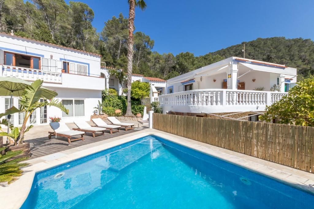 a villa with a swimming pool and a house at Villa Cala Xuclar in Portinatx