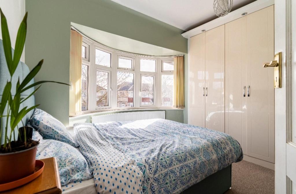 1 dormitorio con cama y ventana en Lovely house (Ealing, London) en Londres