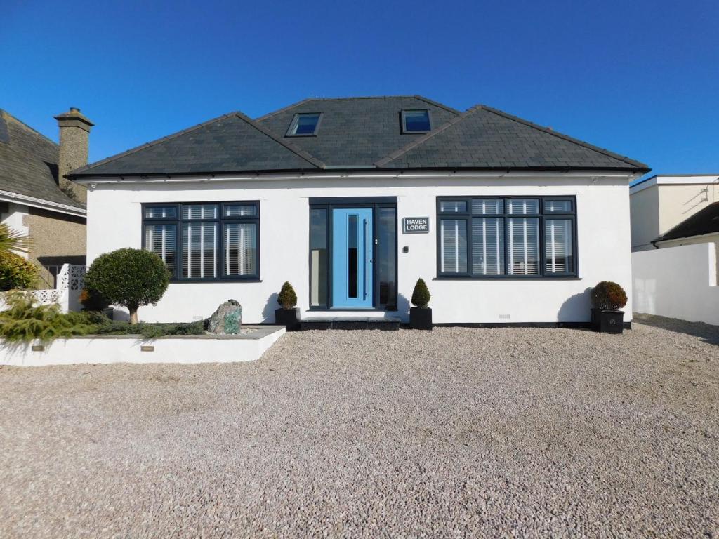紐基的住宿－Haven Lodge Newquay，白色的房子,有蓝色的门