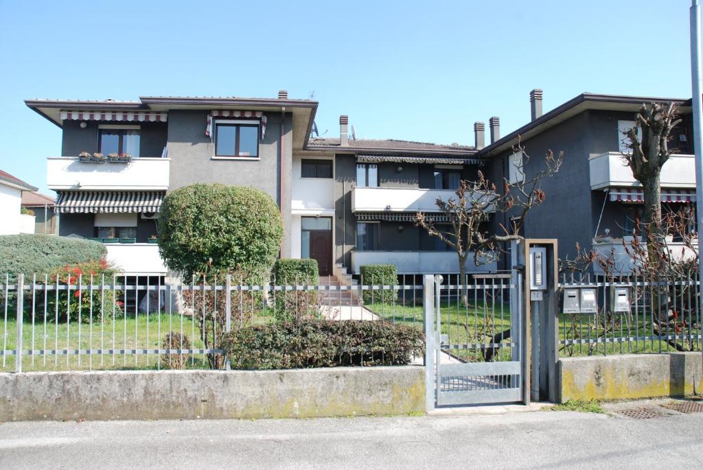 uma cerca em frente a um edifício com uma casa em Appartamento Vera em Ponte San Nicolo