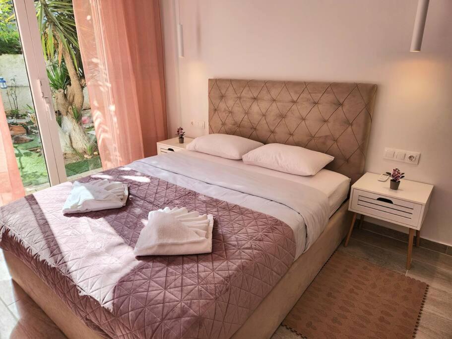 - une chambre avec un grand lit et 2 serviettes dans l'établissement Nice Apartment near Flisvos, à Athènes