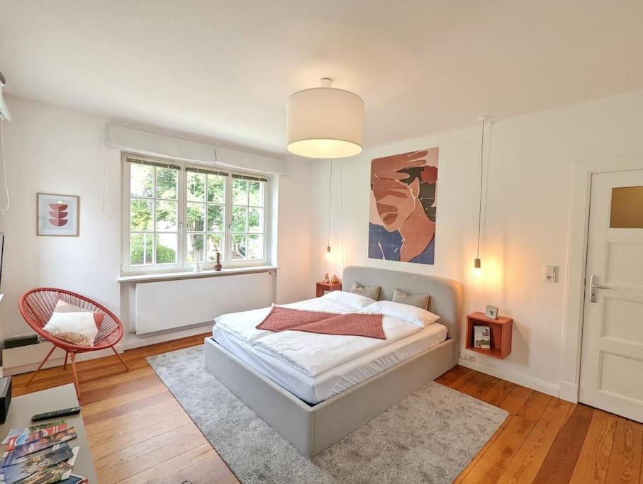 een witte slaapkamer met een bed en een raam bij Stylisches Villa-Apartment in Schlossgartennähe in Schwerin