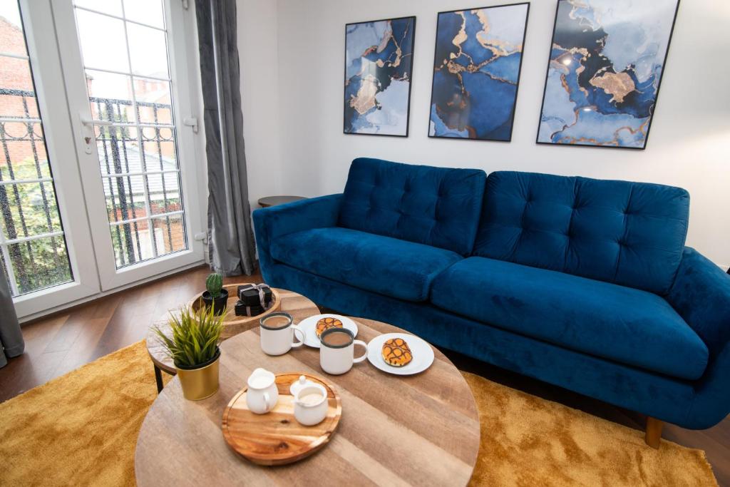 a living room with a blue couch and a table at Pride Park House in Derby