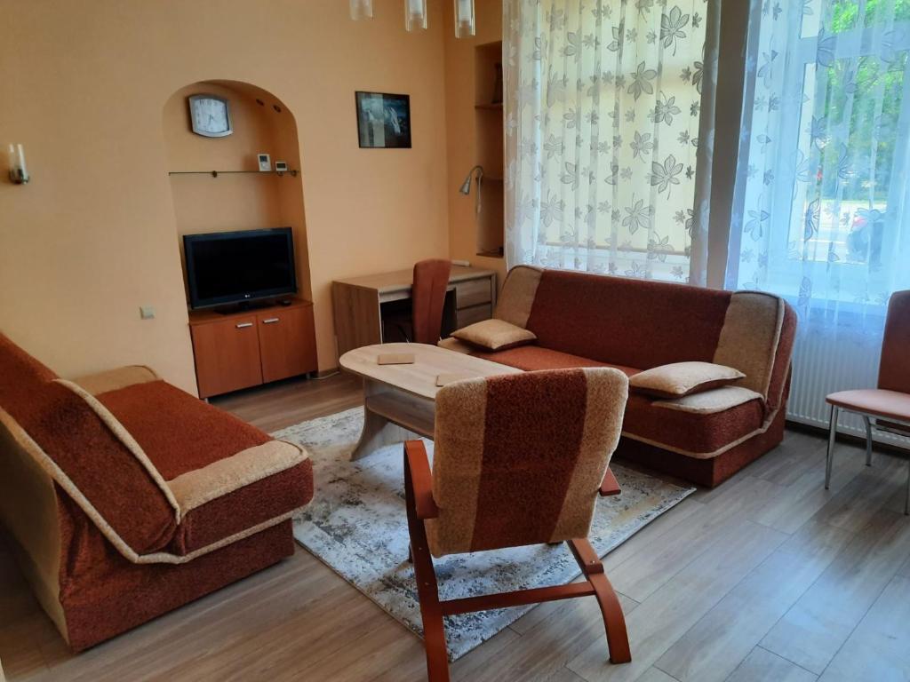 a living room with a couch and chairs and a tv at Startpunkt in Kołobrzeg