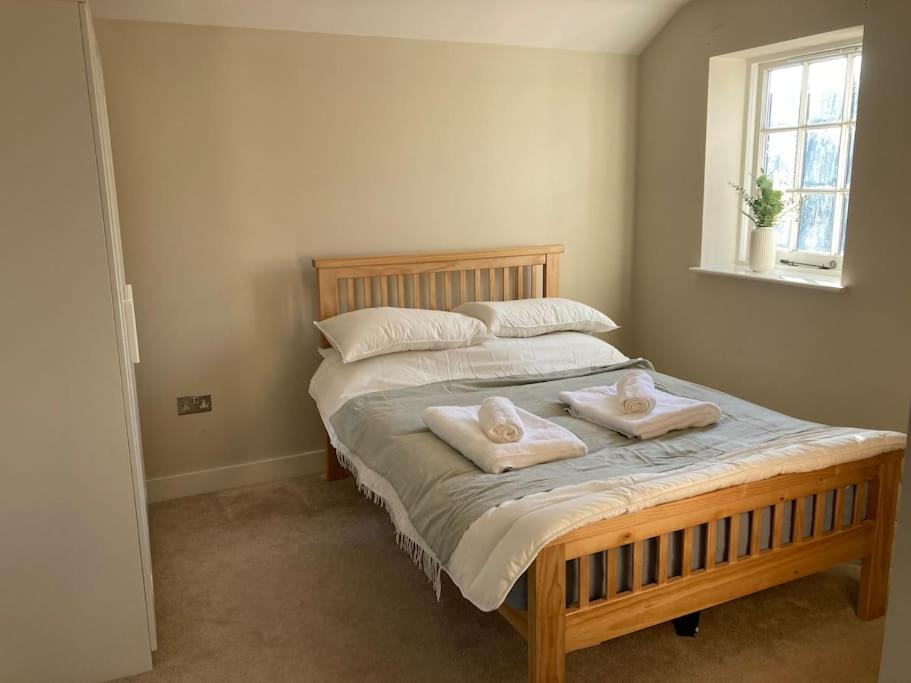 a bedroom with a bed with two towels on it at In the heart of the new forest in Fordingbridge