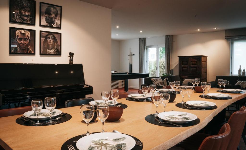 een lange tafel in een kamer met een piano bij MOLO house - cosy house with sunny garden and bbq in silent surroundings - near the BEACH - ideal for families and quiet groups - 15 km from BRUGES in Blankenberge