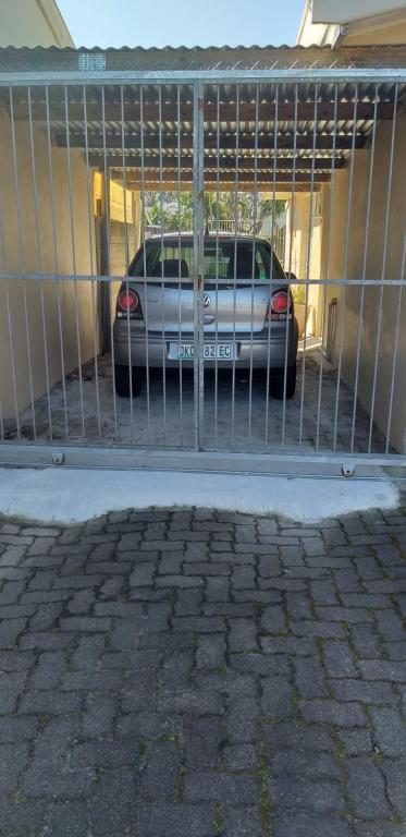 un coche aparcado en un garaje detrás de una puerta en San-Lou Airbnb, en Sunridge Park
