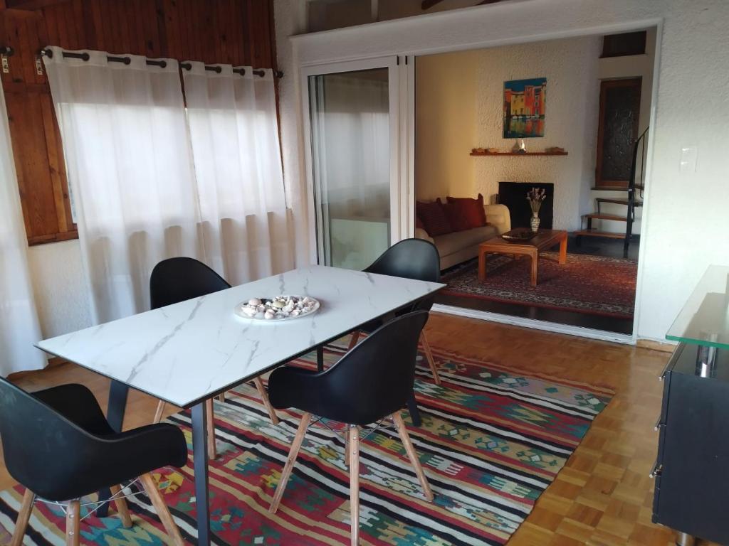 a living room with a white table and chairs at SUNNY APARTMENT NORTHERN ATHENS in Athens