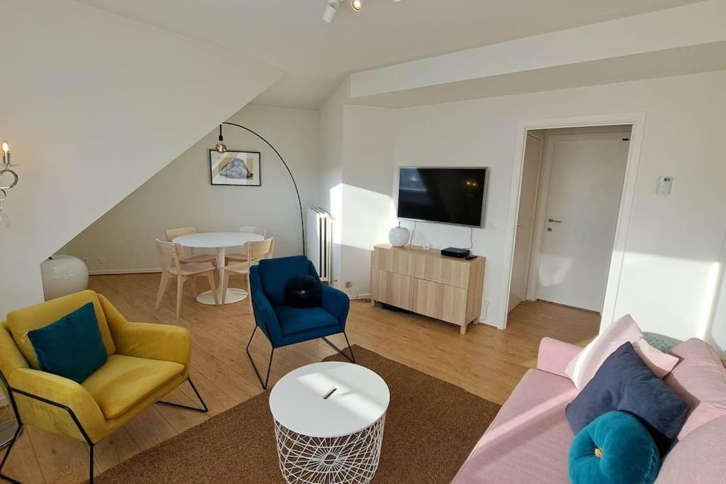 uma sala de estar com um sofá, cadeiras e uma mesa em Chez la Baronne em Bruxelas