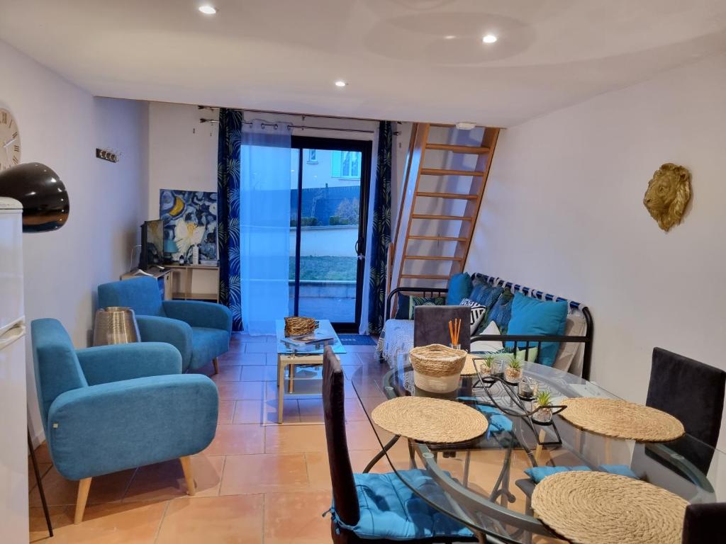 une salle à manger avec des chaises bleues et une table dans l'établissement les gîtes d 'EVANE 