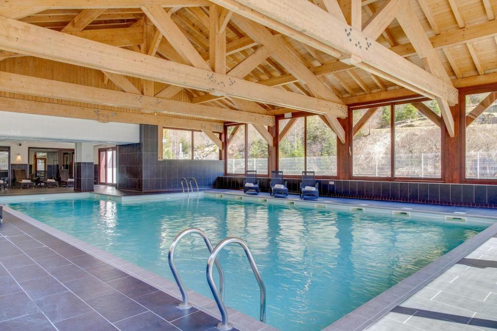 una gran piscina en un edificio con techos de madera en Le calme, le confort, la nature, skis aux pieds, à 15 kilomètres de Chamonix en Vallorcine
