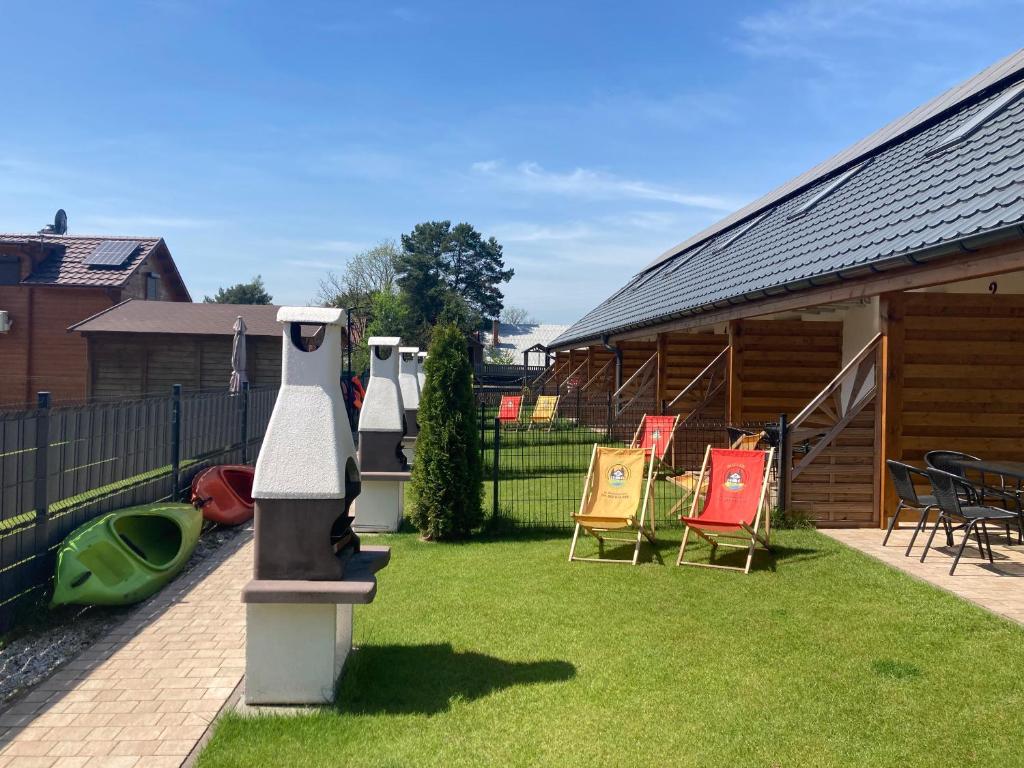 einen Hof mit Stühlen und ein Haus mit Vogelfutter in der Unterkunft Domki nad jeziorem "Apartamenty Wieleń" in Wielen Zaobrzanski