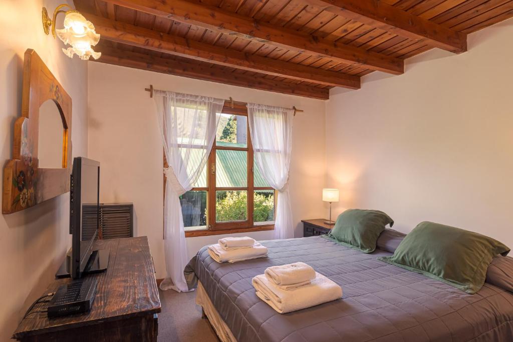 聖馬丁德洛斯安第斯的住宿－Cabaña en el Centro，一间卧室配有一张床,上面有两条毛巾