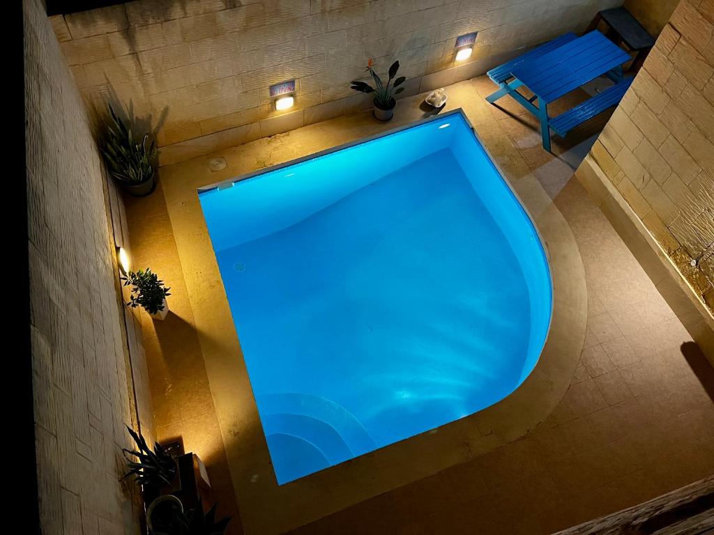 an overhead view of a large blue swimming pool at Encanto Vegetarian Bed & Breakfast in Xagħra