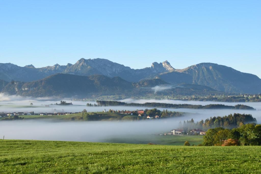 un valle nublado con montañas en el fondo en Ferienwohnung Allgäuer Landhaus Stocker in Hopferau-Füssen, en Hopferau