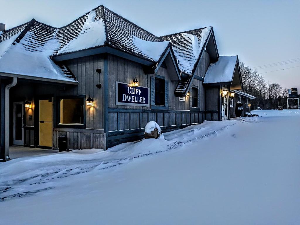 un bâtiment avec un panneau indiquant la ville unie dans la neige dans l'établissement Cliff Dweller on Lake Superior, à Tofte