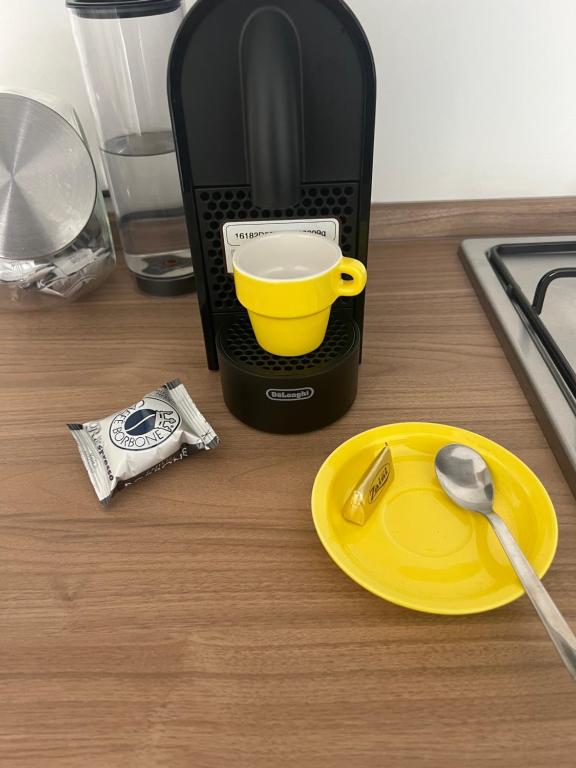 eine Kaffeemaschine mit einer gelben Tasse auf dem Tisch in der Unterkunft Appartamento La Fenice in Genua