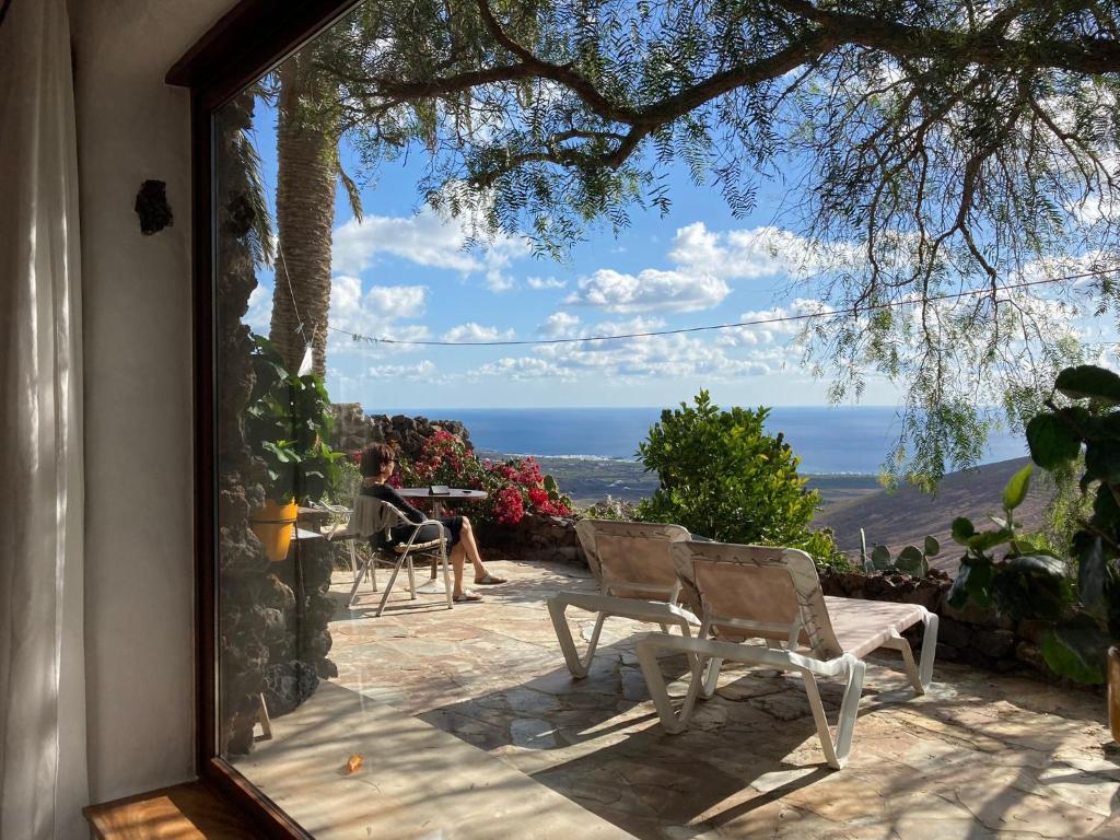 una ventana de cristal de una casa con vistas al océano en Apartamento Pirul, en Haría