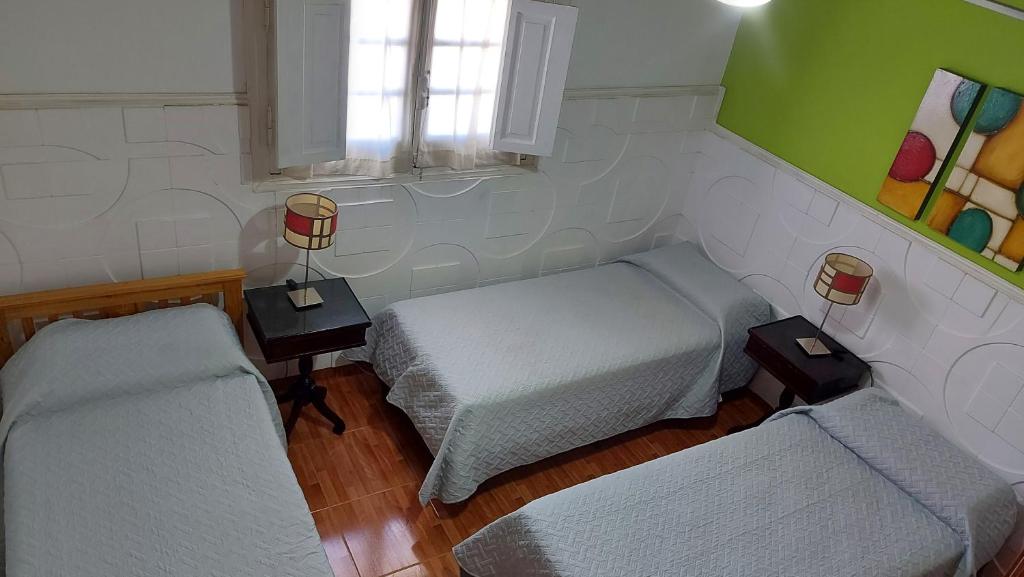 Habitación pequeña con 2 camas y ventana en Hosteria Villa del Lago en Villa Carlos Paz