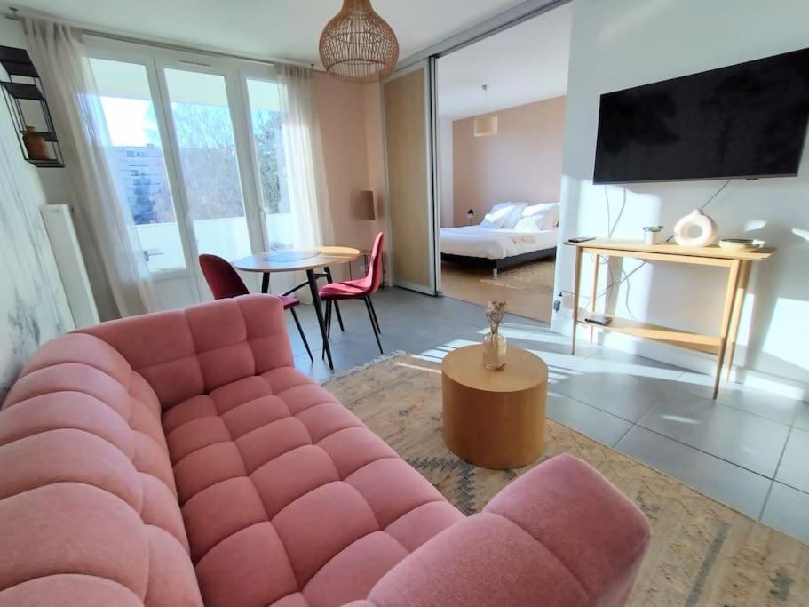a living room with a pink couch and a table at L'Authentique ~ Lac 1 km ~ Parking gratuit in Annecy