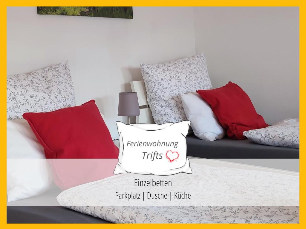 Habitación con sofá y almohadas rojas y blancas. en Ferienwohnung Trifts | Einzelbetten | Parkplatz, en Wangen im Allgäu