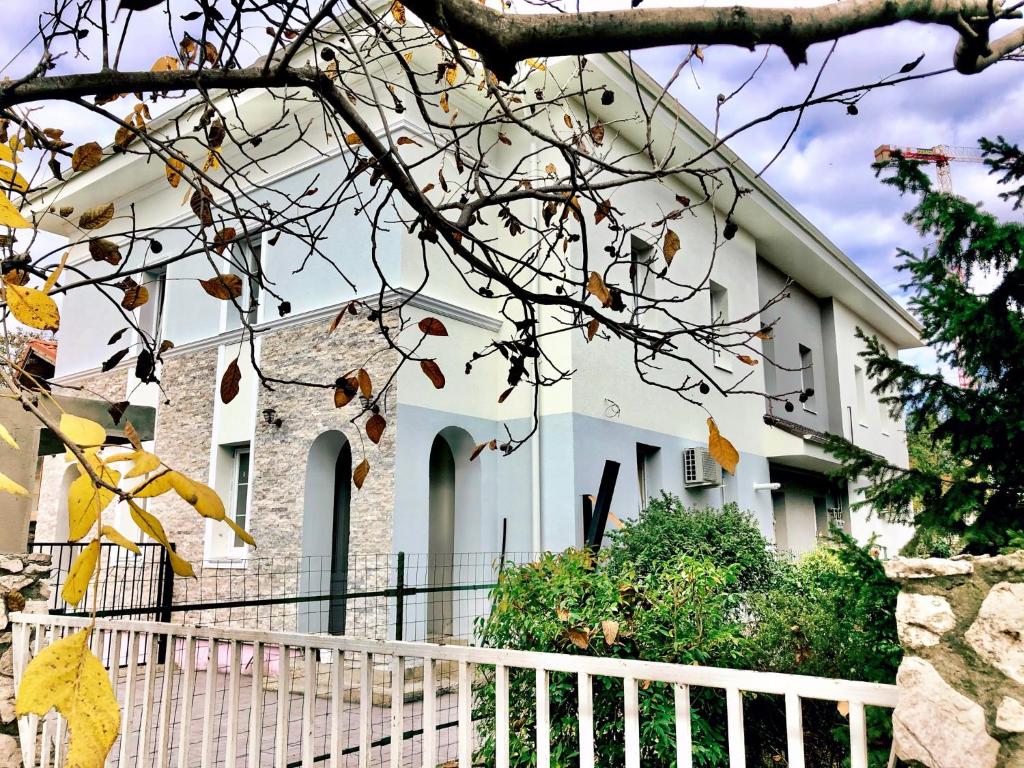 a white house with a white fence in front of it at Cozy Apartament with 2Rooms in Timişoara