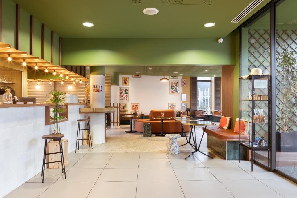 a lobby of a store with tables and chairs at ibis Styles Versailles Saint Quentin en Yvelines in Saint-Cyr-lʼÉcole