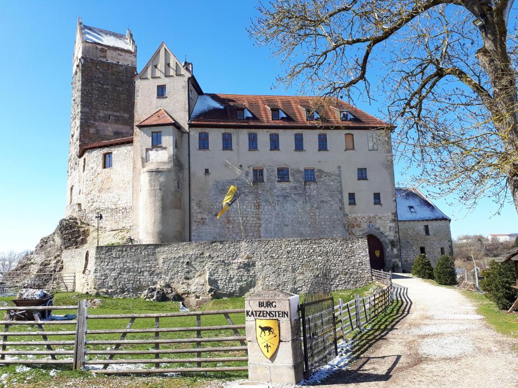 un grand château avec une clôture devant lui dans l'établissement Burg Katzenstein, à Katzenstein