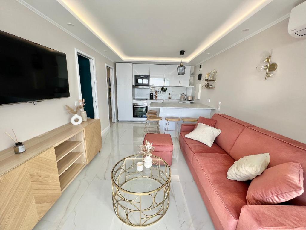 ein Wohnzimmer mit einem roten Sofa und einem Tisch in der Unterkunft Luxueux appartement - vue mer - piscine - free parking - Monaco in Cap d'Ail