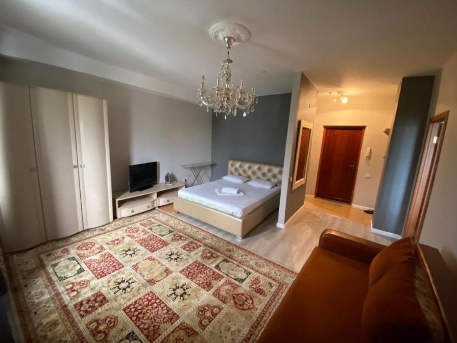 - un salon avec un lit et un lustre dans l'établissement Уютные апартаменты, à Almaty