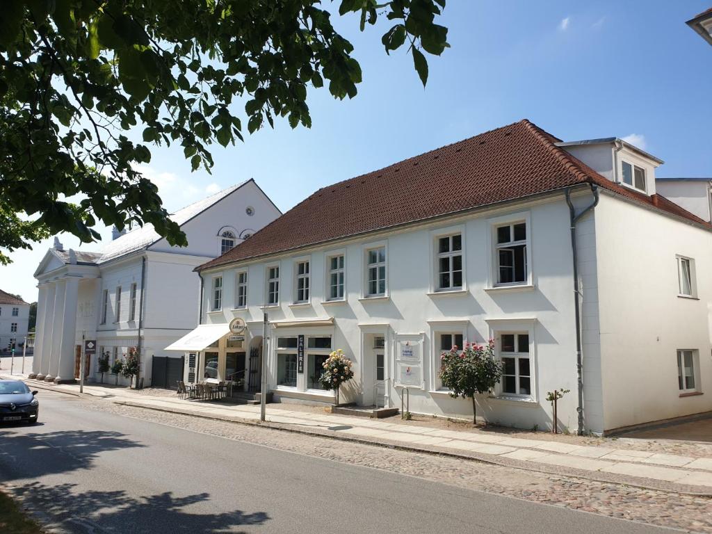 Une rangée de bâtiments blancs dans une rue dans l'établissement DTS Appartements, à Putbus