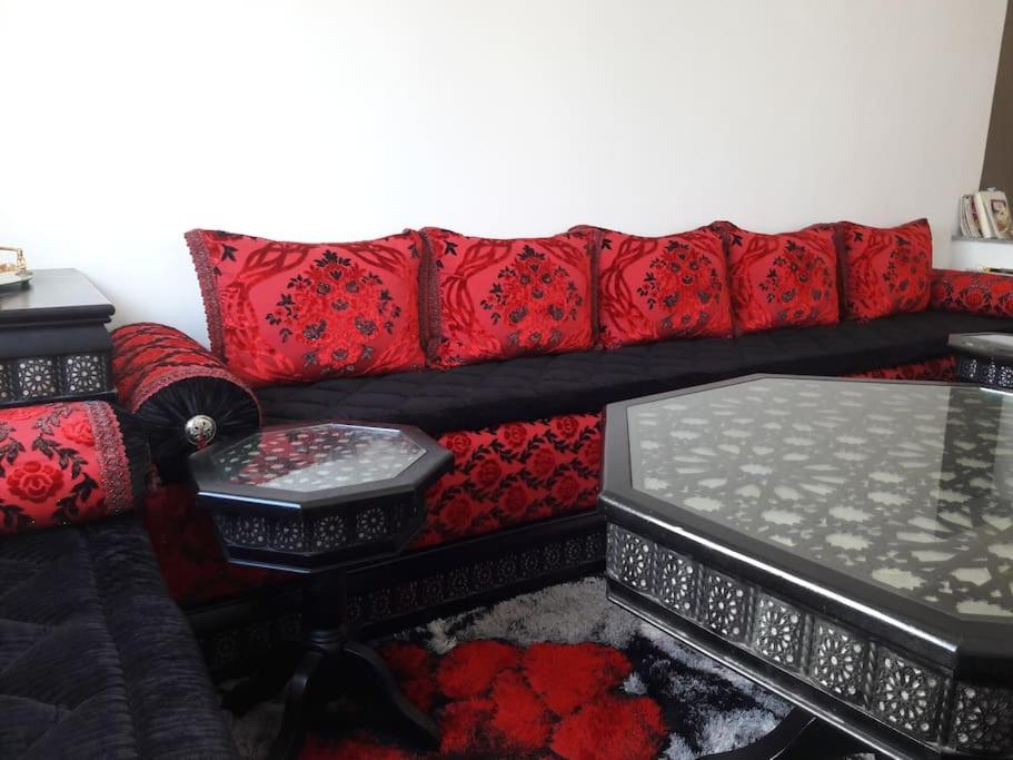 - un canapé noir et rouge avec des oreillers rouges et une table dans l'établissement Appartement centre-ville agadir, à Agadir