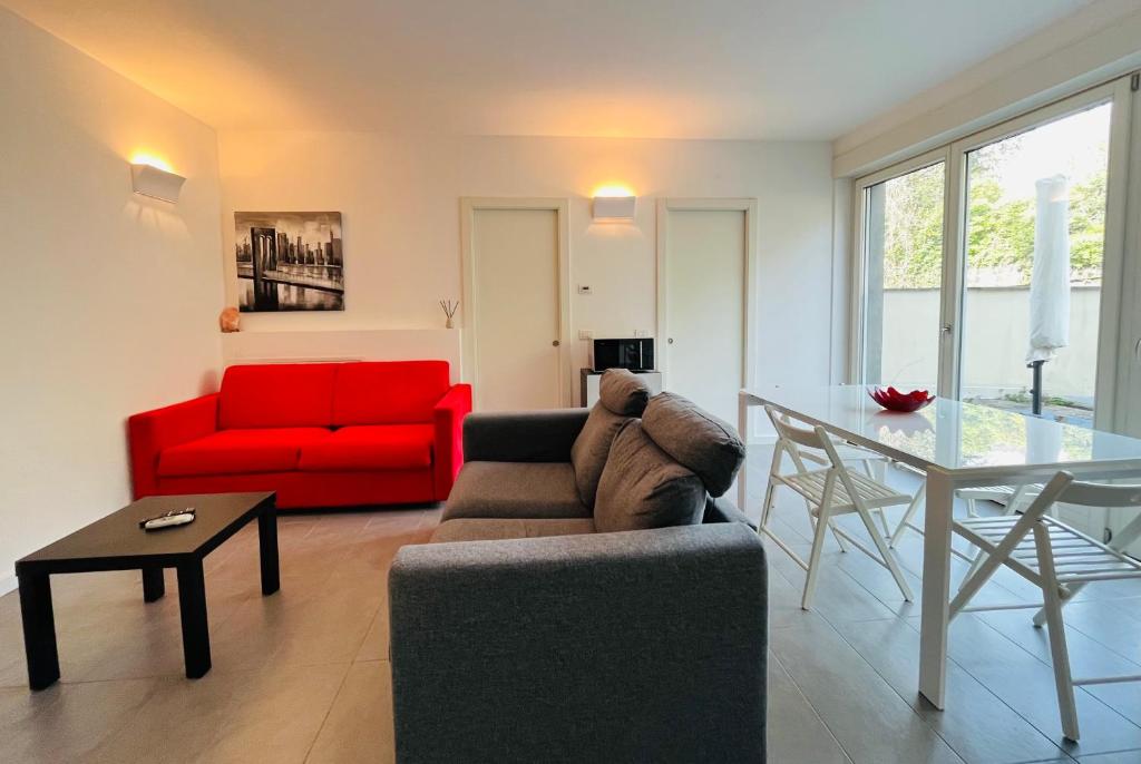 - un salon avec un canapé rouge et une table dans l'établissement Appartamento Magnolia Residenza Prealba, à Levanto