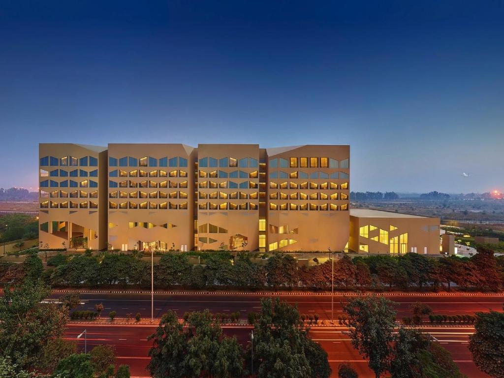 a large white building with trees in front of it at Vivanta New Delhi, Dwarka in New Delhi