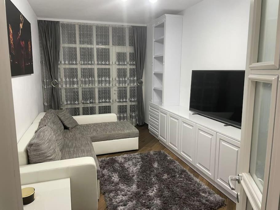 a living room with a couch and a flat screen tv at Lovely 1 bedroom apartment with parking in Iaşi