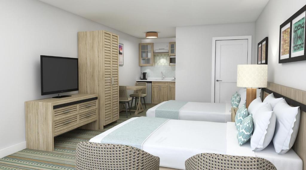 Habitación de hotel con 2 camas y TV de pantalla plana. en Mahalo Cape May, en Cape May
